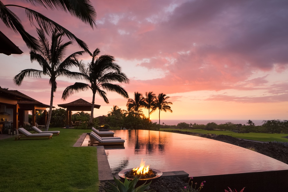 World-inspired back custom shaped infinity swimming pool in Hawaii with a bar area.