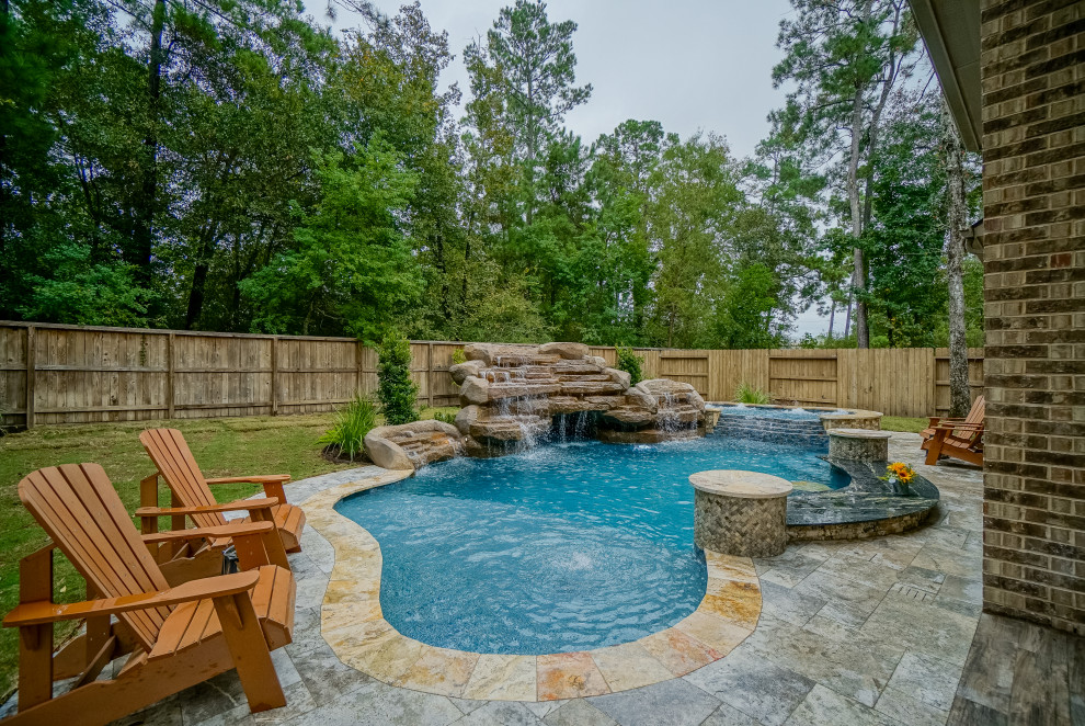 Modelo de piscina exótica grande a medida en patio trasero con adoquines de piedra natural