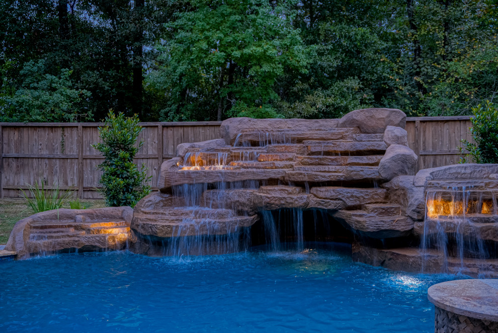 Cette photo montre une grande piscine arrière exotique sur mesure avec des pavés en pierre naturelle.