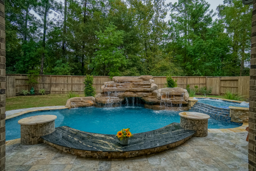 Inspiration for a large world-inspired back custom shaped swimming pool in Houston with natural stone paving.