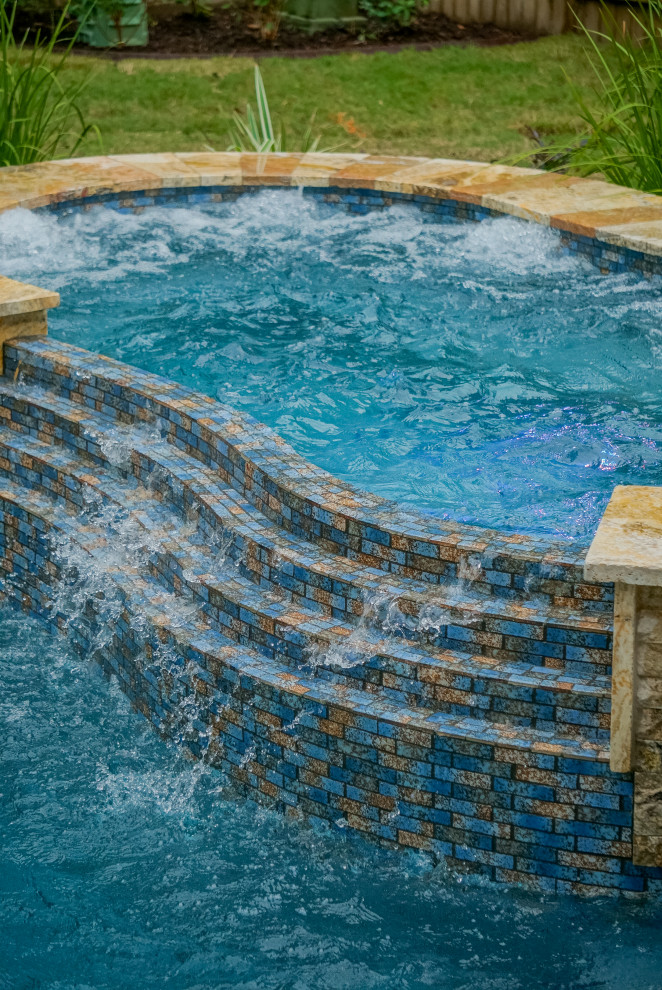 Großer Pool hinter dem Haus in individueller Form mit Natursteinplatten in Houston