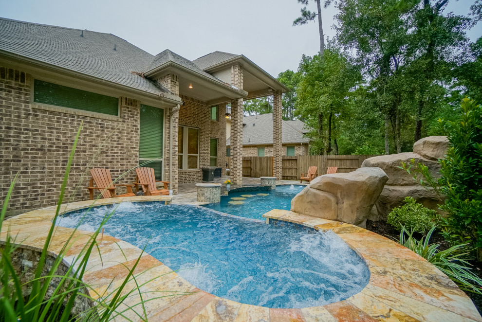 Modelo de piscina tropical grande a medida en patio trasero con adoquines de piedra natural