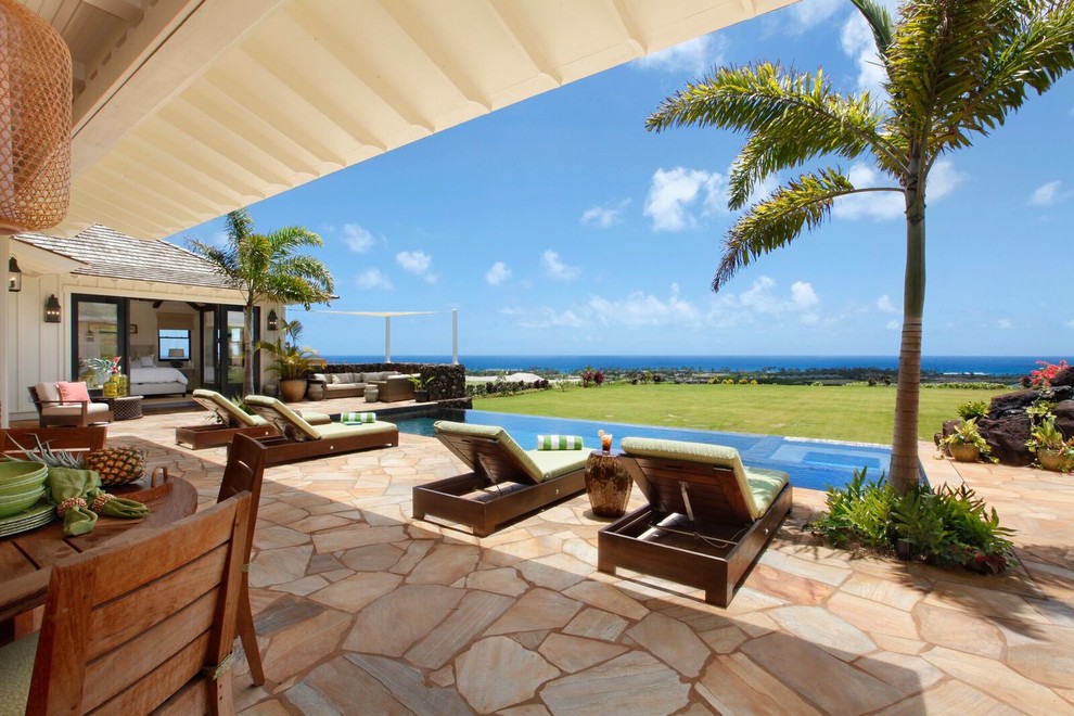 Großer Maritimer Pool hinter dem Haus in rechteckiger Form mit Natursteinplatten in Hawaii