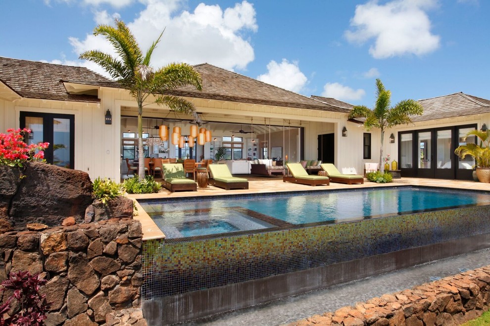 Großer Maritimer Pool hinter dem Haus in rechteckiger Form mit Natursteinplatten in Hawaii