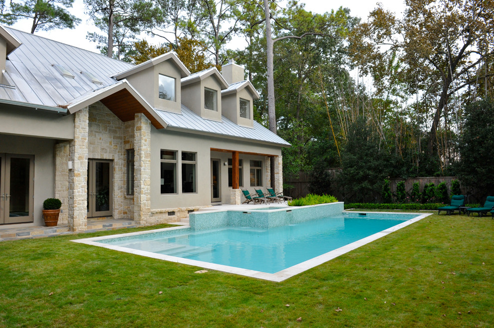 Esempio di una grande piscina monocorsia classica rettangolare dietro casa con una vasca idromassaggio