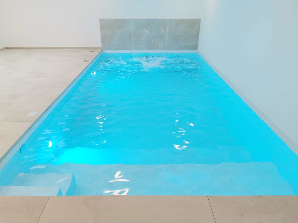 Foto de piscina contemporánea de tamaño medio interior y rectangular con suelo de baldosas