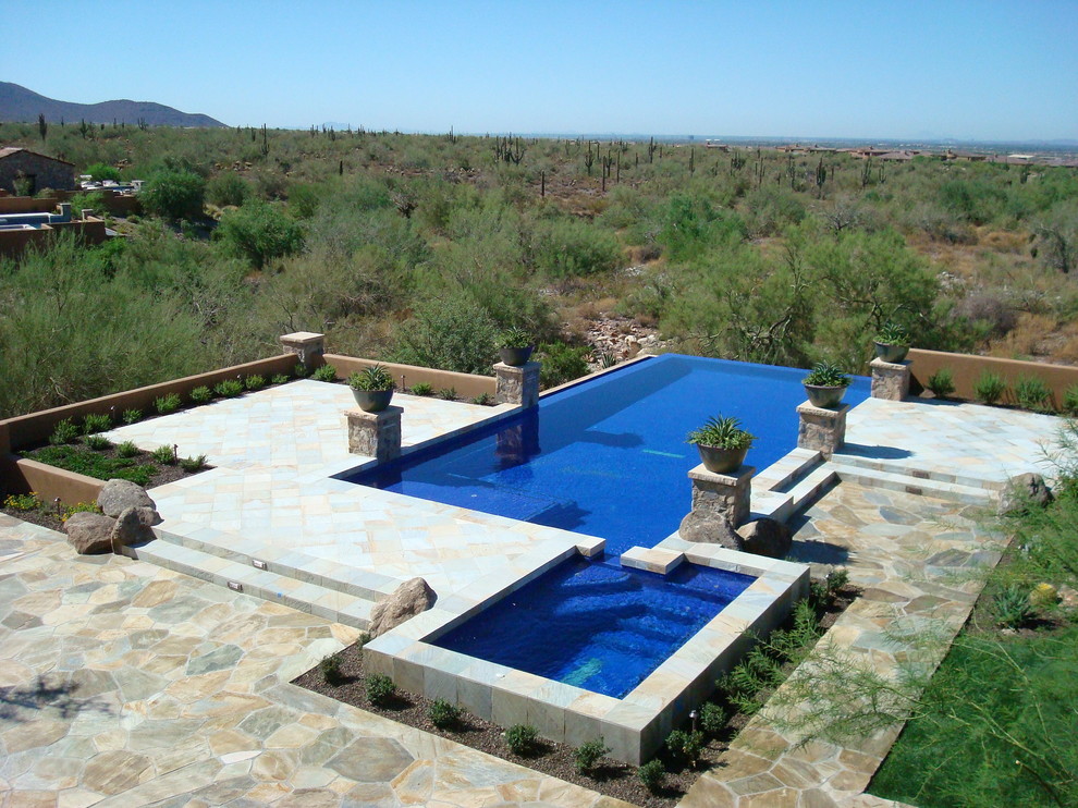 Mediterranean swimming pool in Phoenix with natural stone paving.