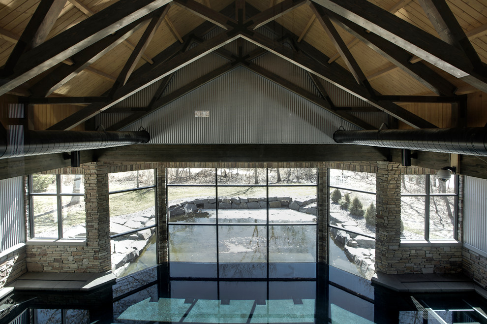 Ispirazione per una grande piscina coperta minimal personalizzata con pavimentazioni in cemento
