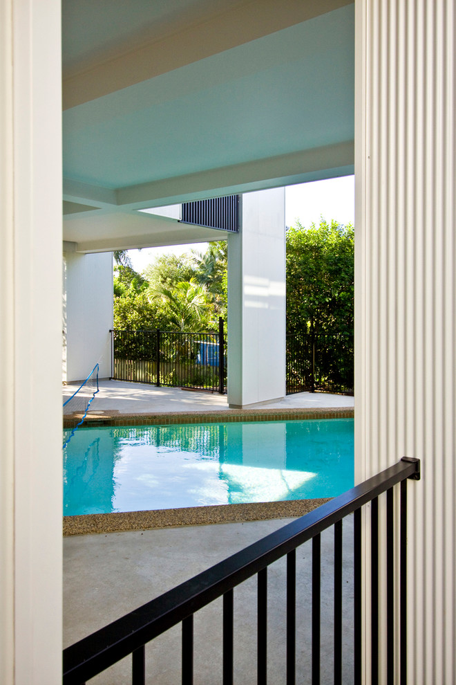 Inspiration för en stor funkis anpassad pool på baksidan av huset, med betongplatta