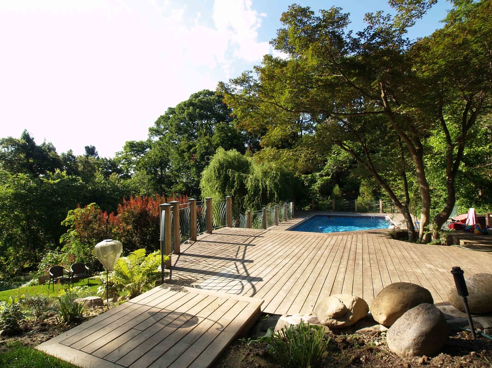Aménagement d'une grande piscine naturelle et arrière craftsman rectangle avec une terrasse en bois.