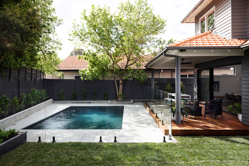 На фото: естественный, прямоугольный бассейн на заднем дворе в современном стиле с покрытием из каменной брусчатки с