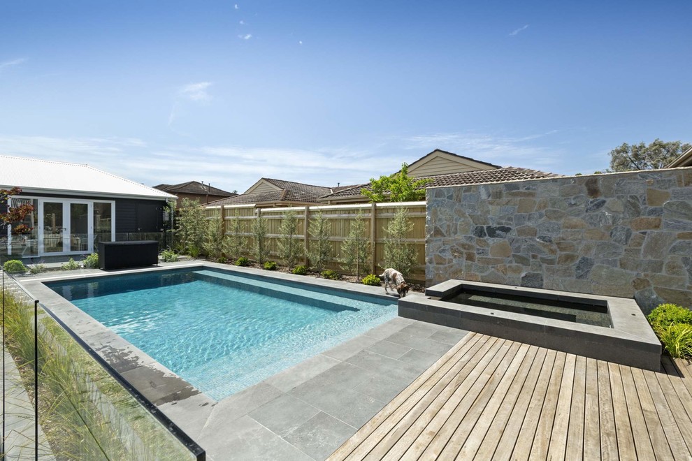 Diseño de piscinas y jacuzzis contemporáneos rectangulares en patio trasero con adoquines de hormigón