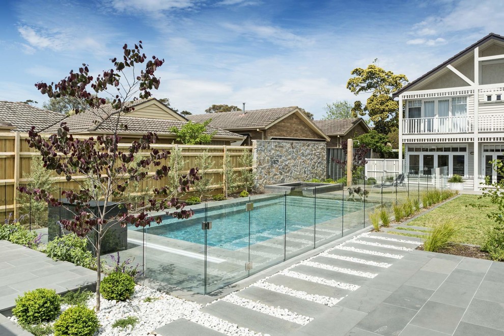 Immagine di una piscina design rettangolare dietro casa con una vasca idromassaggio e pavimentazioni in cemento