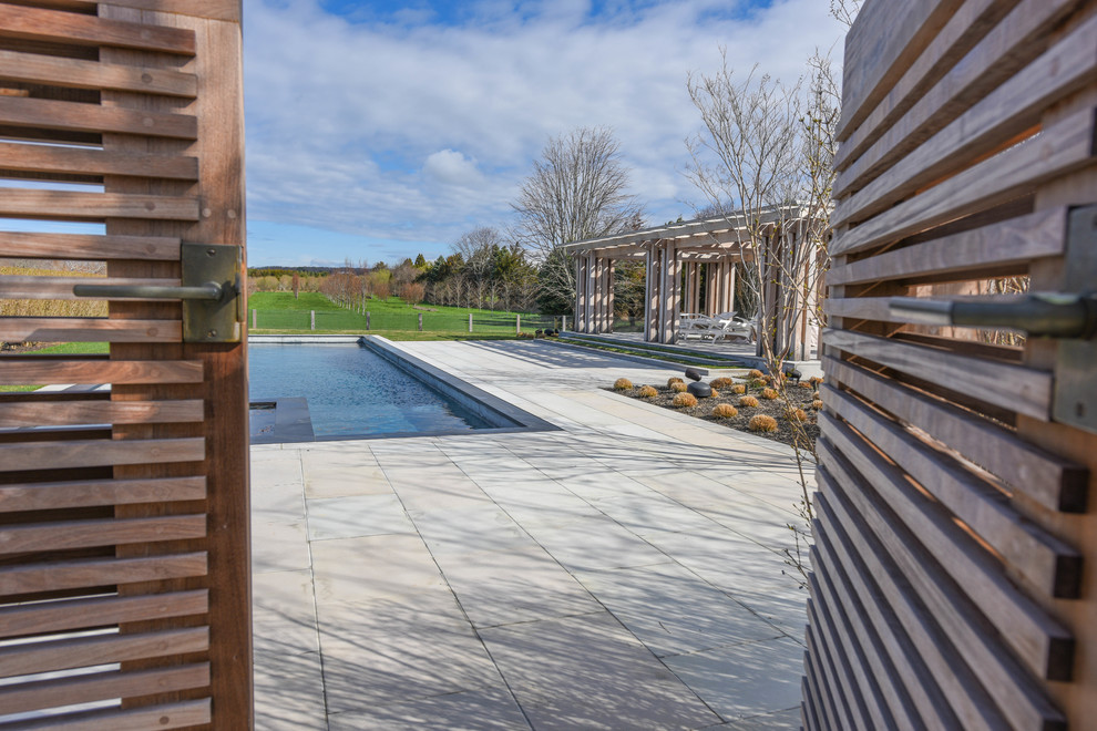 Пример оригинального дизайна: большой наземный, прямоугольный бассейн на заднем дворе в классическом стиле с покрытием из плитки