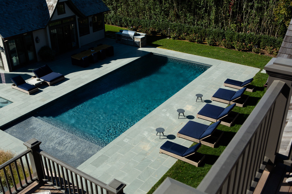 Diseño de piscina costera rectangular en patio trasero con suelo de baldosas