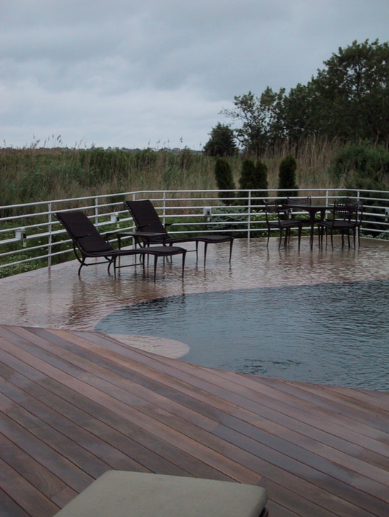 Idées déco pour une grande piscine à débordement et arrière moderne sur mesure avec des pavés en pierre naturelle.