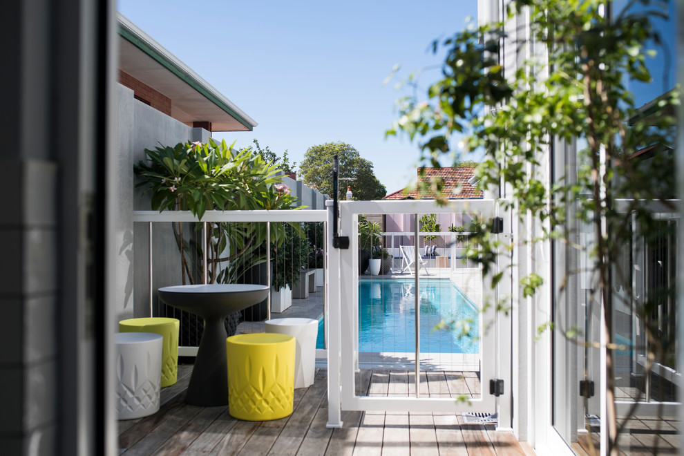 Ejemplo de piscina alargada clásica renovada de tamaño medio rectangular en patio trasero con adoquines de piedra natural