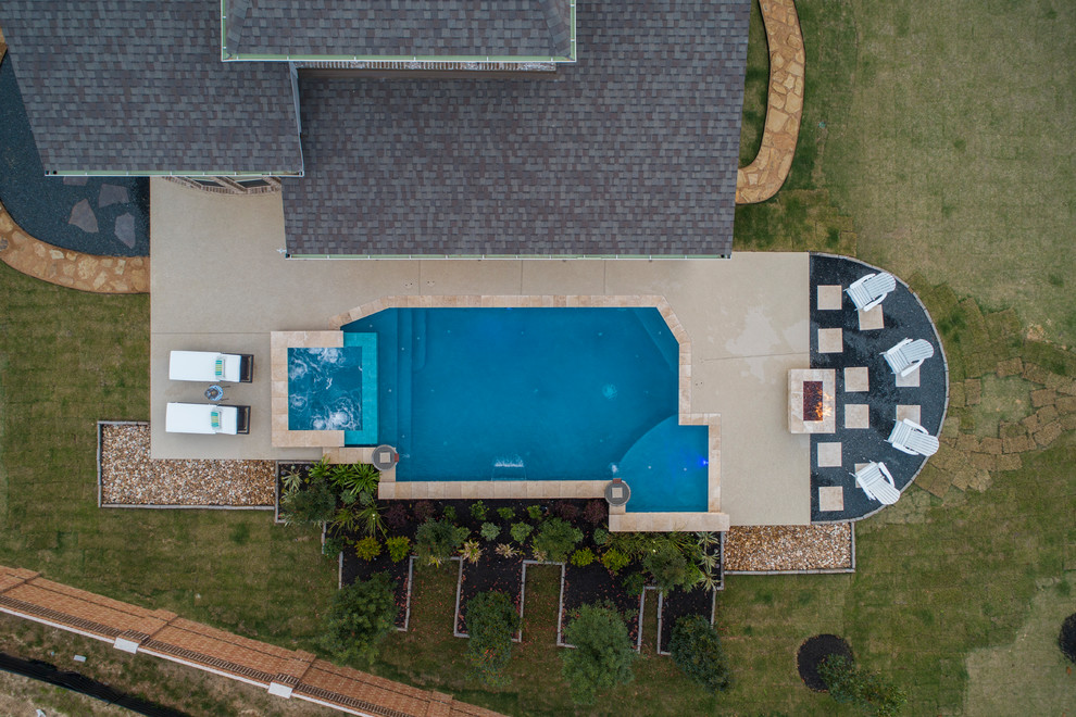 Idée de décoration pour une grande piscine arrière craftsman rectangle avec un bain bouillonnant et une terrasse en bois.