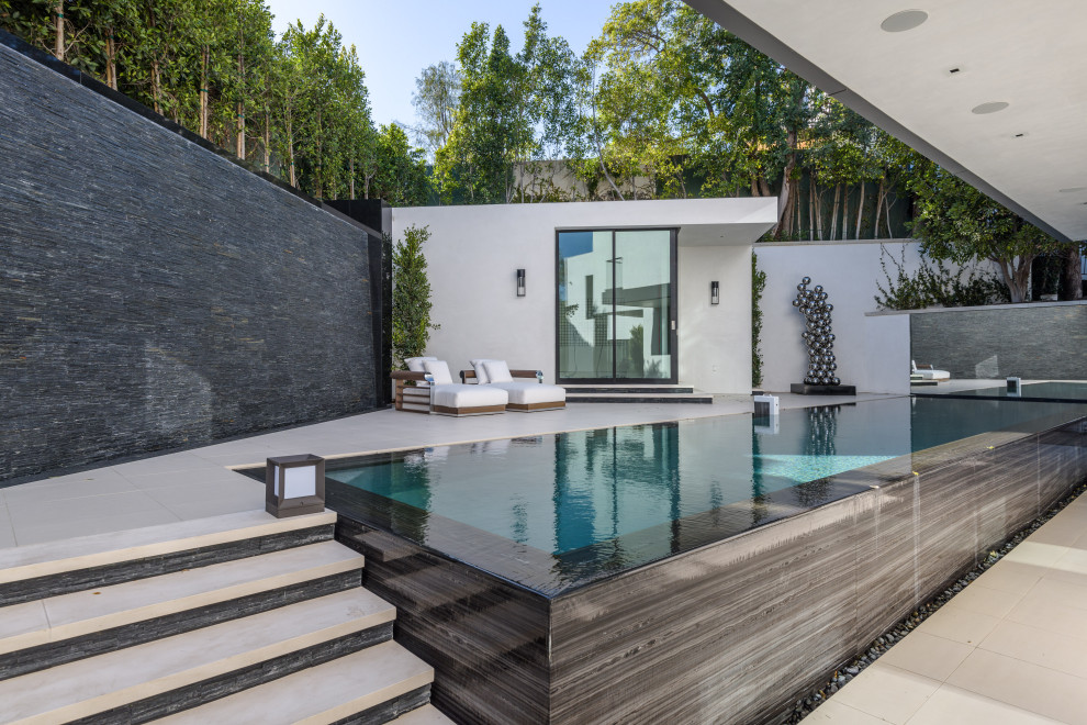 Inspiration for a mid-sized modern backyard tile and rectangular infinity pool house remodel in Orange County