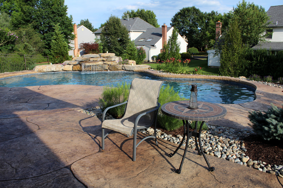 Classic back custom shaped natural swimming pool in Philadelphia with stamped concrete.
