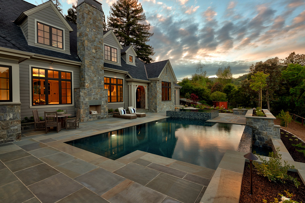 Ejemplo de piscinas y jacuzzis infinitos contemporáneos de tamaño medio rectangulares en patio trasero con adoquines de piedra natural