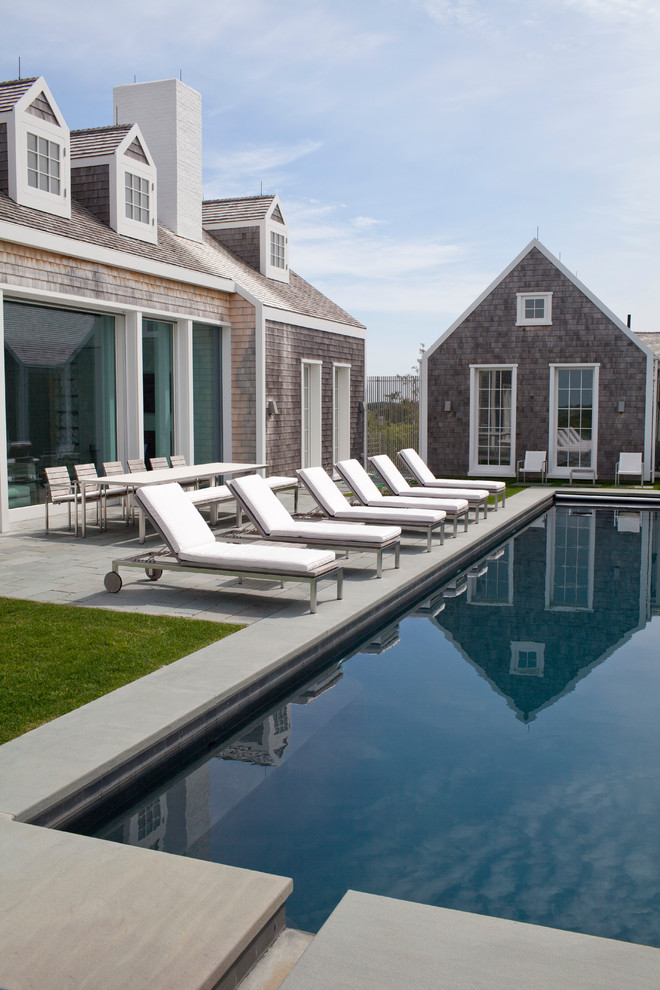 Diseño de casa de la piscina y piscina alargada costera de tamaño medio rectangular en patio lateral con adoquines de piedra natural