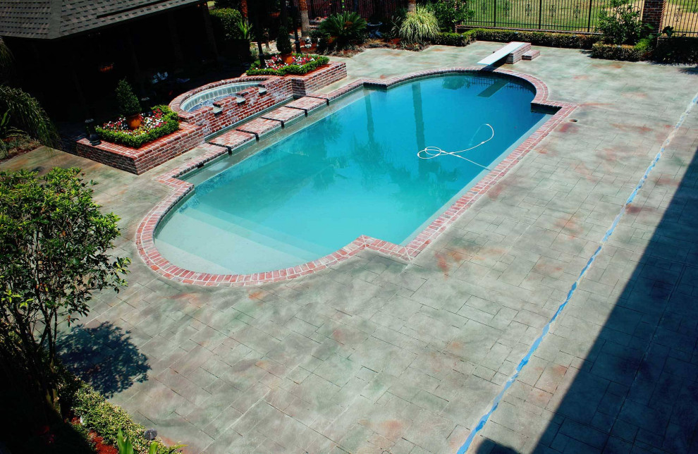 Imagen de piscinas y jacuzzis tradicionales grandes a medida en patio trasero con suelo de hormigón estampado