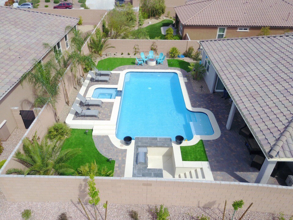 Großer Klassischer Pool hinter dem Haus in L-Form mit Pflastersteinen in Las Vegas