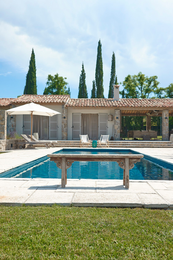 На фото: прямоугольный бассейн среднего размера на боковом дворе в средиземноморском стиле с домиком у бассейна и покрытием из каменной брусчатки