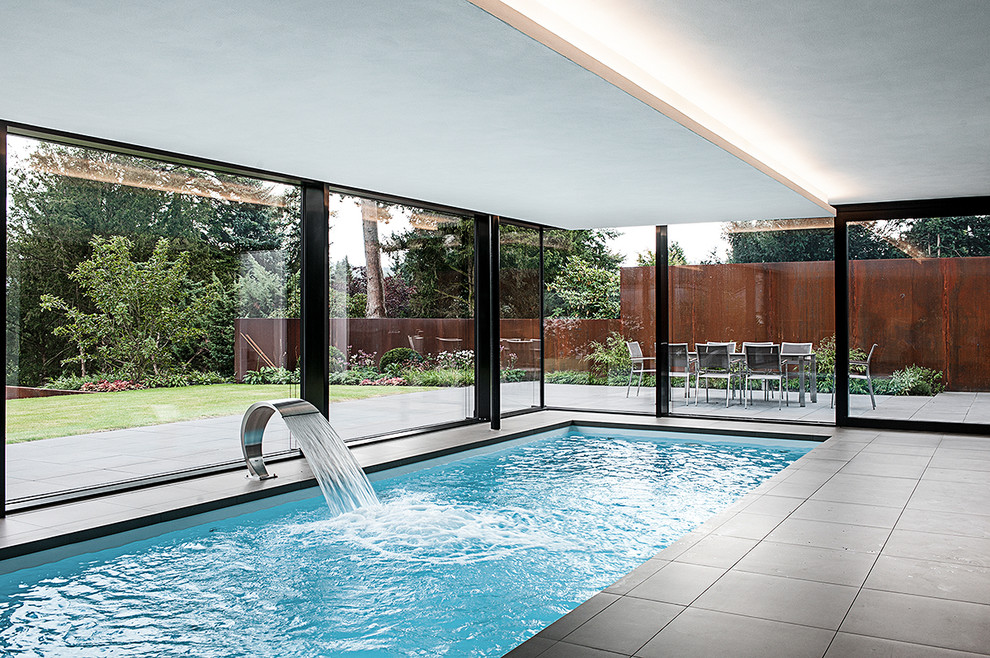 Ejemplo de piscina actual de tamaño medio interior y rectangular con suelo de baldosas