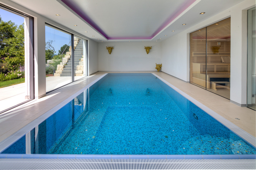 Foto de piscina actual de tamaño medio rectangular y interior con suelo de baldosas