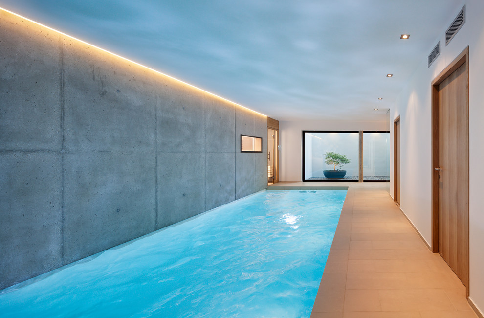 На фото: прямоугольный бассейн среднего размера в доме в стиле модернизм с покрытием из плитки