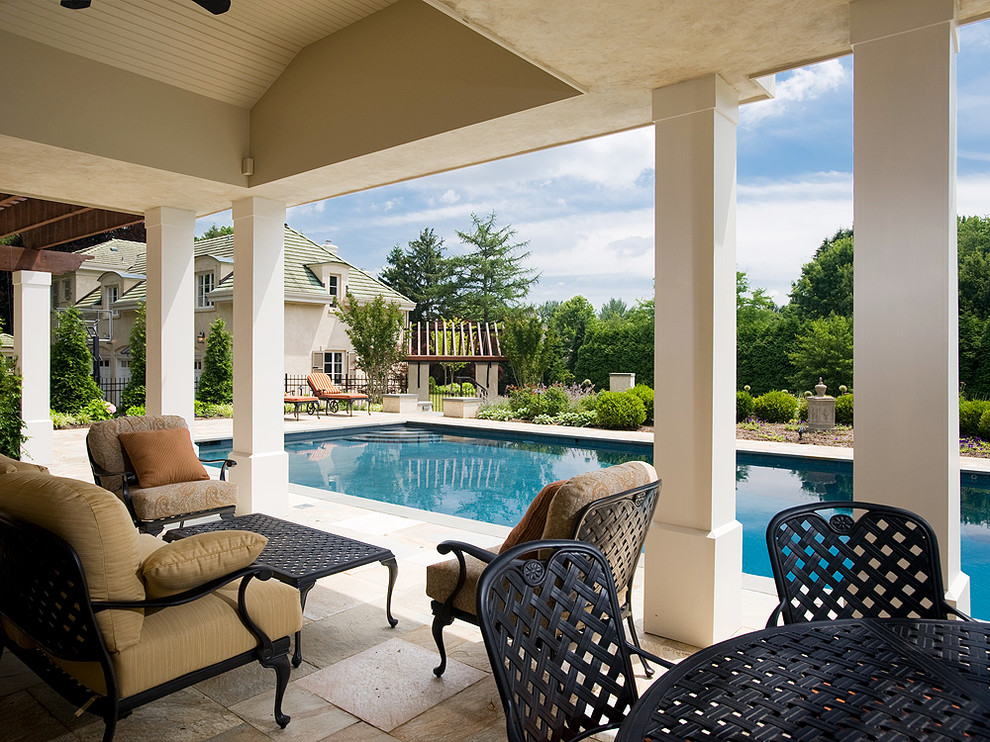На фото: прямоугольный бассейн среднего размера на заднем дворе в викторианском стиле с домиком у бассейна и покрытием из каменной брусчатки