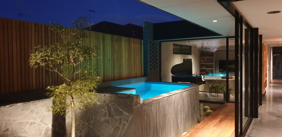 Cette image montre une petite piscine hors-sol minimaliste sur mesure avec une cour et du béton estampé.