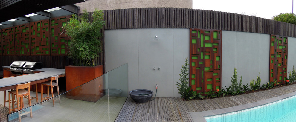 Idée de décoration pour un grand couloir de nage arrière design sur mesure avec une terrasse en bois.