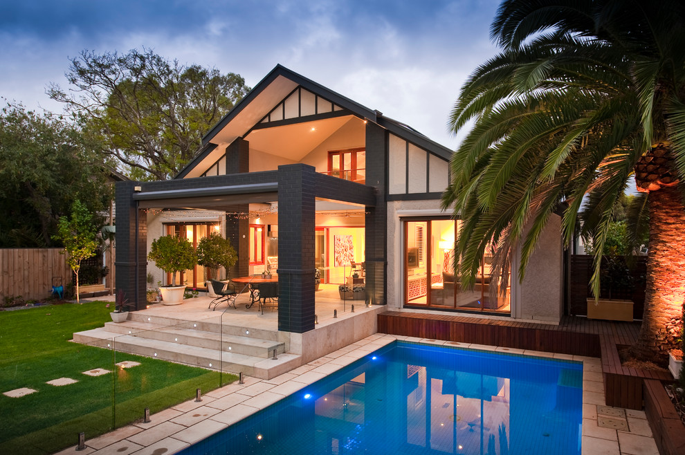 Idee per una grande piscina naturale tropicale rettangolare dietro casa con piastrelle