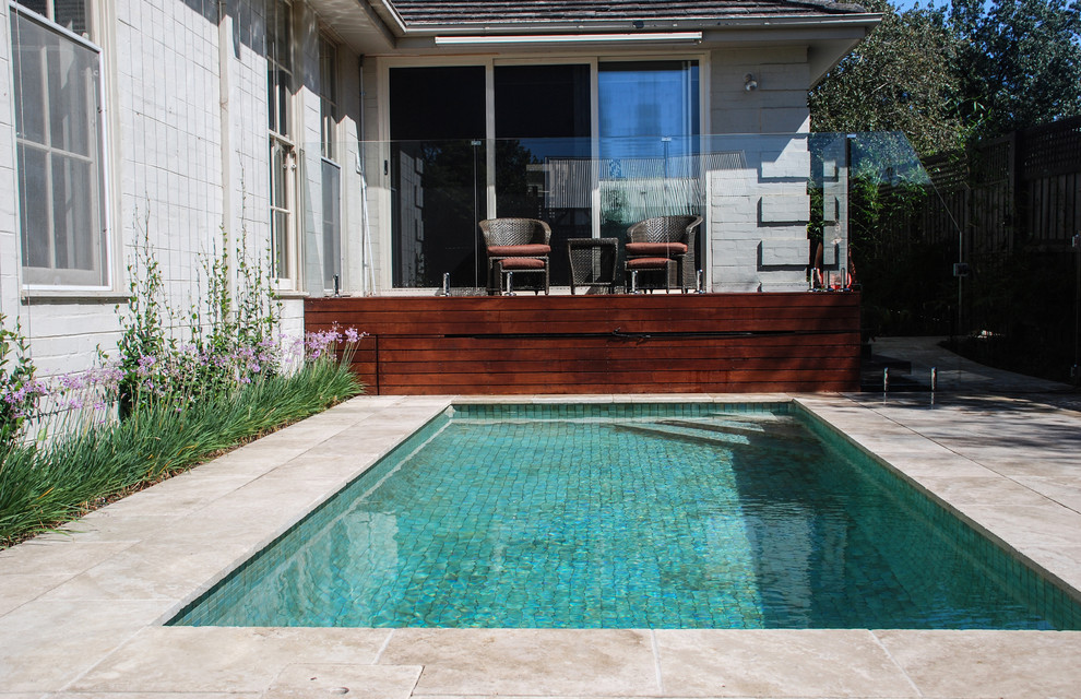 Diseño de piscina contemporánea de tamaño medio rectangular en patio trasero con paisajismo de piscina y adoquines de piedra natural