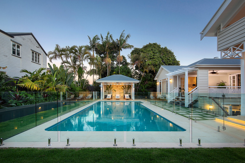 Ejemplo de casa de la piscina y piscina natural costera grande rectangular en patio trasero con adoquines de piedra natural