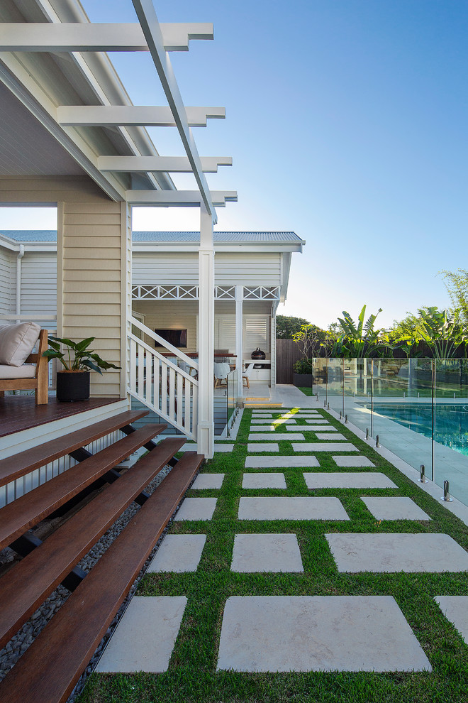 Imagen de casa de la piscina y piscina natural costera grande rectangular en patio trasero con adoquines de piedra natural