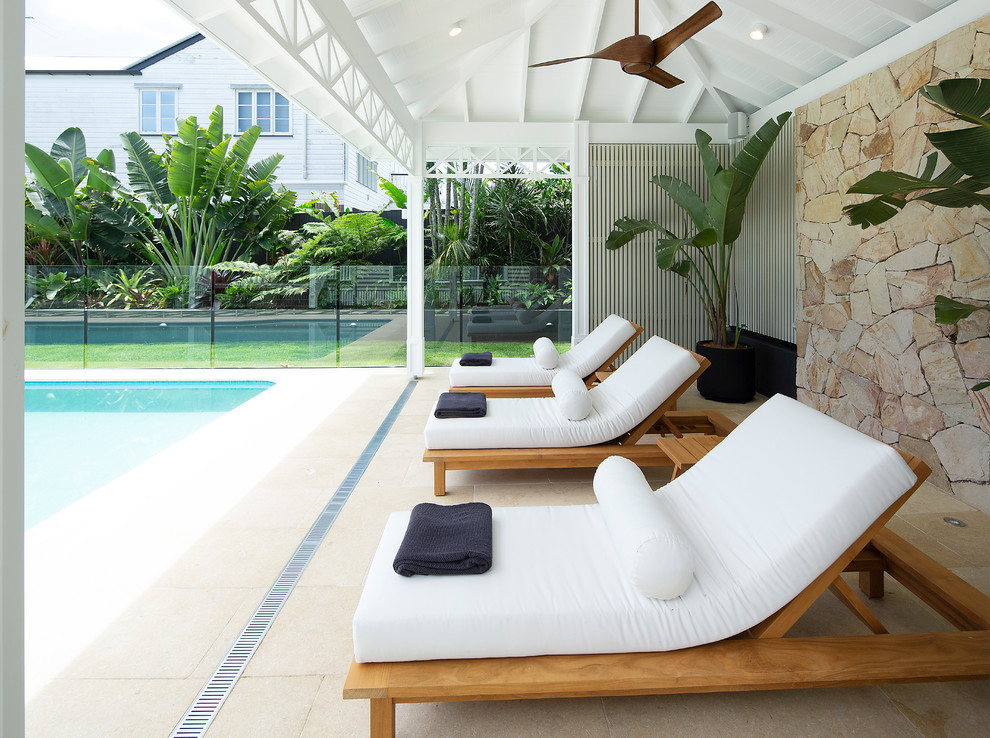 На фото: большой естественный, прямоугольный бассейн на заднем дворе в морском стиле с домиком у бассейна и покрытием из каменной брусчатки