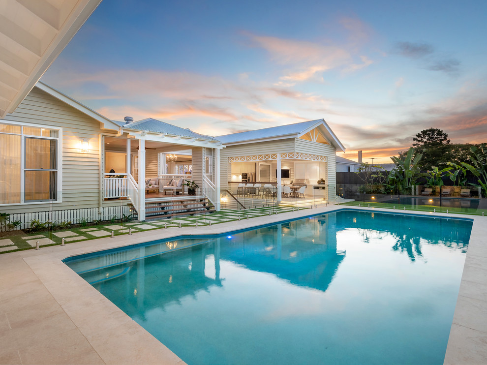 Cette image montre un grand Abris de piscine et pool houses arrière vintage rectangle avec des pavés en pierre naturelle.