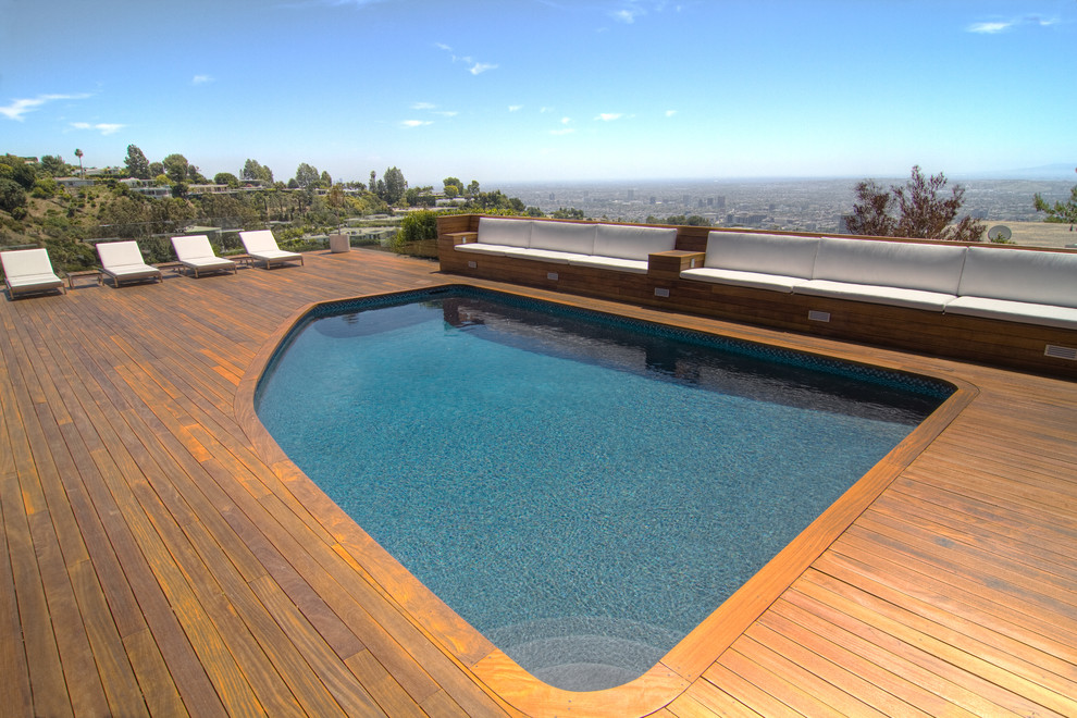 Modelo de piscina contemporánea de tamaño medio a medida en patio trasero con entablado
