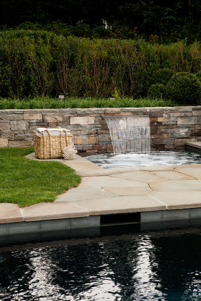 Diseño de piscinas y jacuzzis alargados tradicionales de tamaño medio rectangulares en patio trasero con adoquines de piedra natural