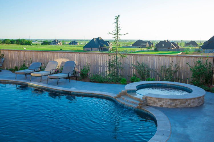 Ejemplo de piscinas y jacuzzis naturales costeros de tamaño medio redondeados en patio trasero con adoquines de piedra natural