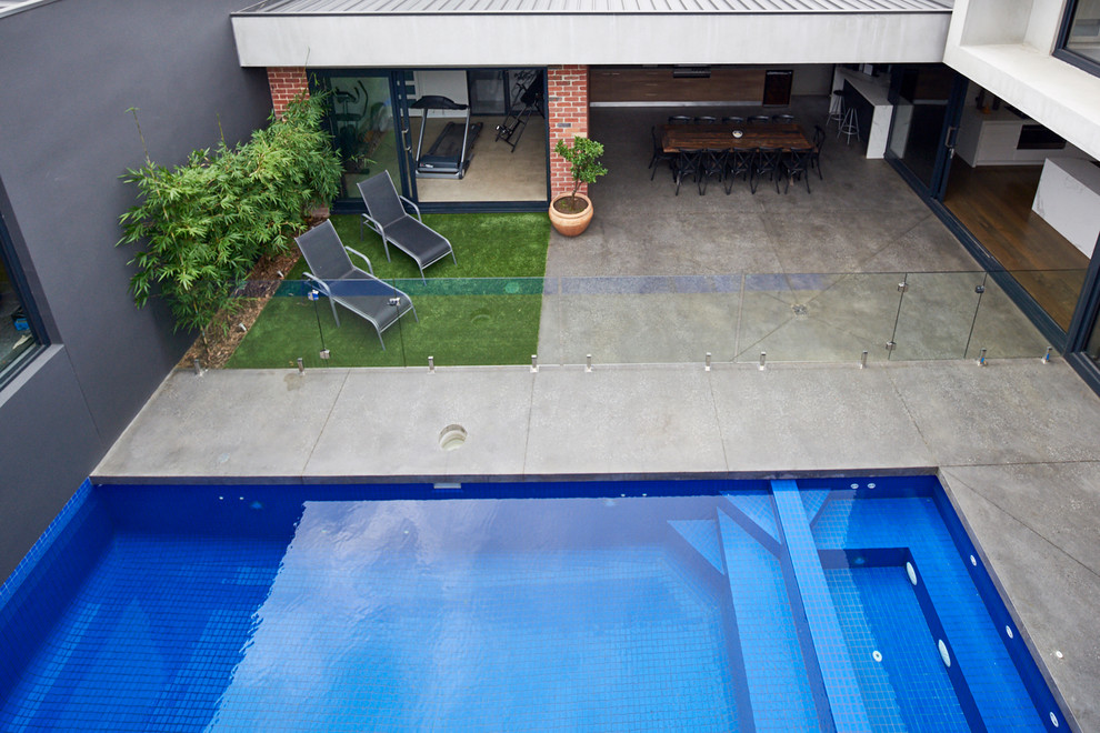 Foto de casa de la piscina y piscina natural moderna de tamaño medio rectangular en patio con losas de hormigón