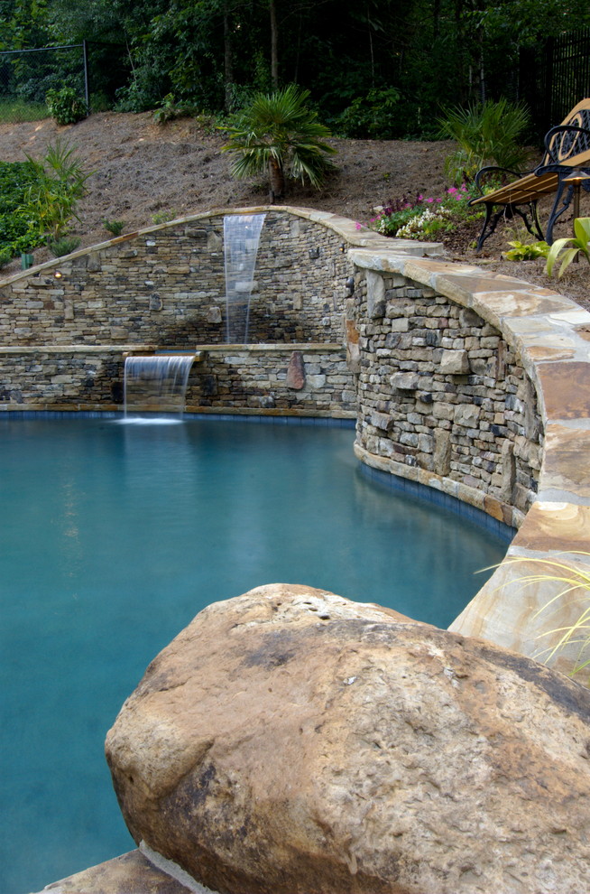 Foto di una piscina naturale rustica personalizzata di medie dimensioni e dietro casa con fontane e pavimentazioni in mattoni