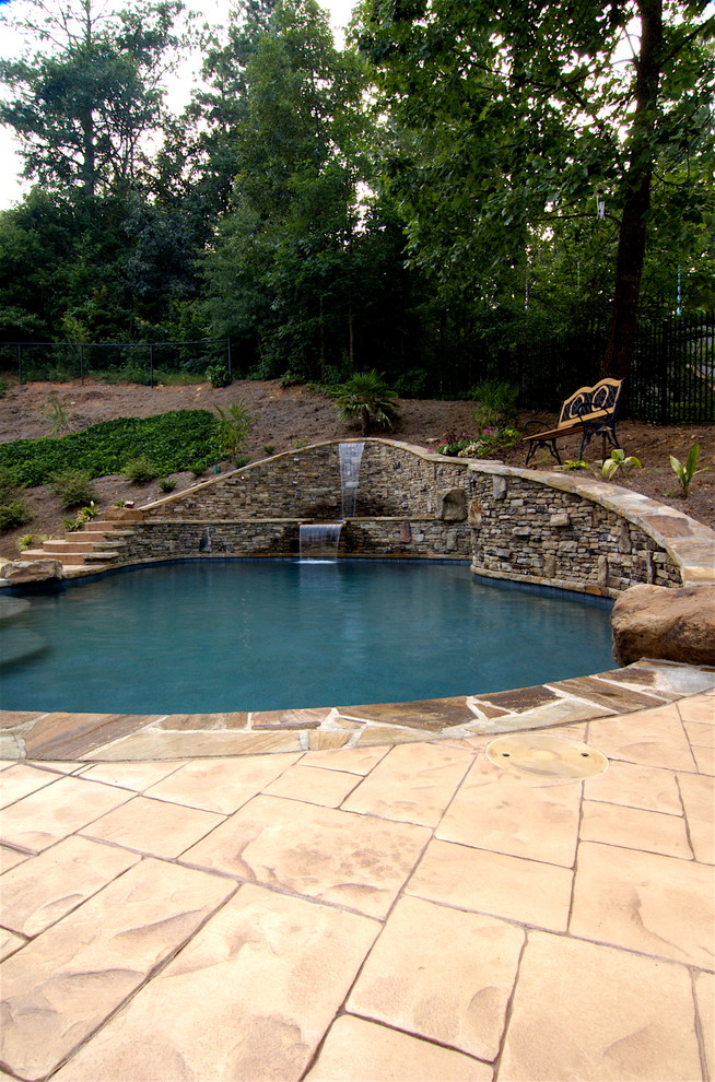 Réalisation d'une piscine naturelle et arrière chalet de taille moyenne et sur mesure avec un point d'eau et des pavés en brique.