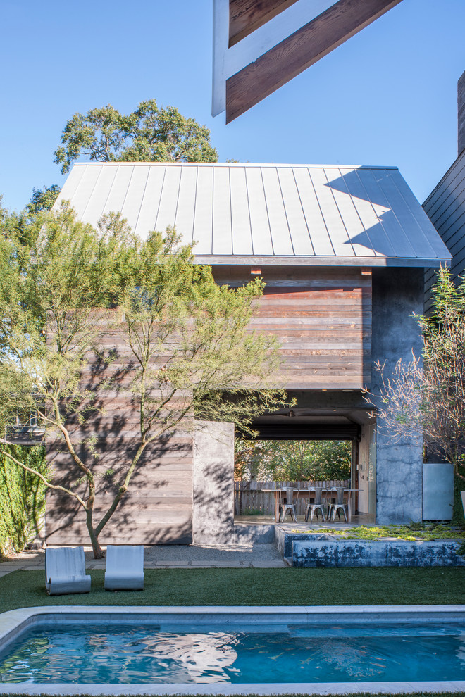 Uriges Poolhaus hinter dem Haus in rechteckiger Form mit Stempelbeton in Houston