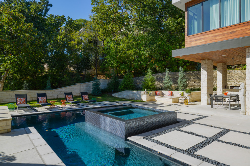 Idee per una grande piscina monocorsia moderna personalizzata dietro casa con una vasca idromassaggio e pavimentazioni in cemento