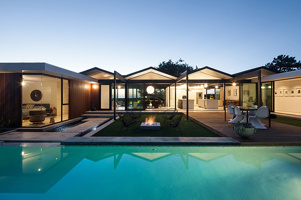 Пример оригинального дизайна: спортивный, прямоугольный бассейн среднего размера на заднем дворе в стиле ретро с джакузи и покрытием из бетонных плит